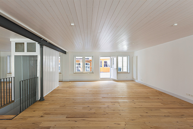 Atelier: ein sehr großer, heller Raum mit Holzdielen. Fensterfront mit Terrassentür.
