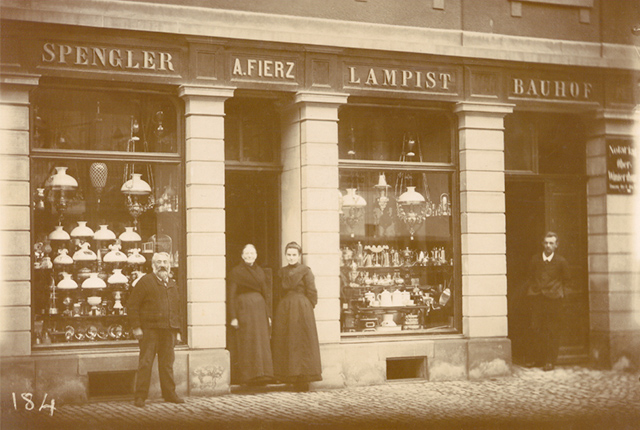 Historisches Foto mit vier Personen (Familie Fierz) vor ihrem Lampengeschäft.